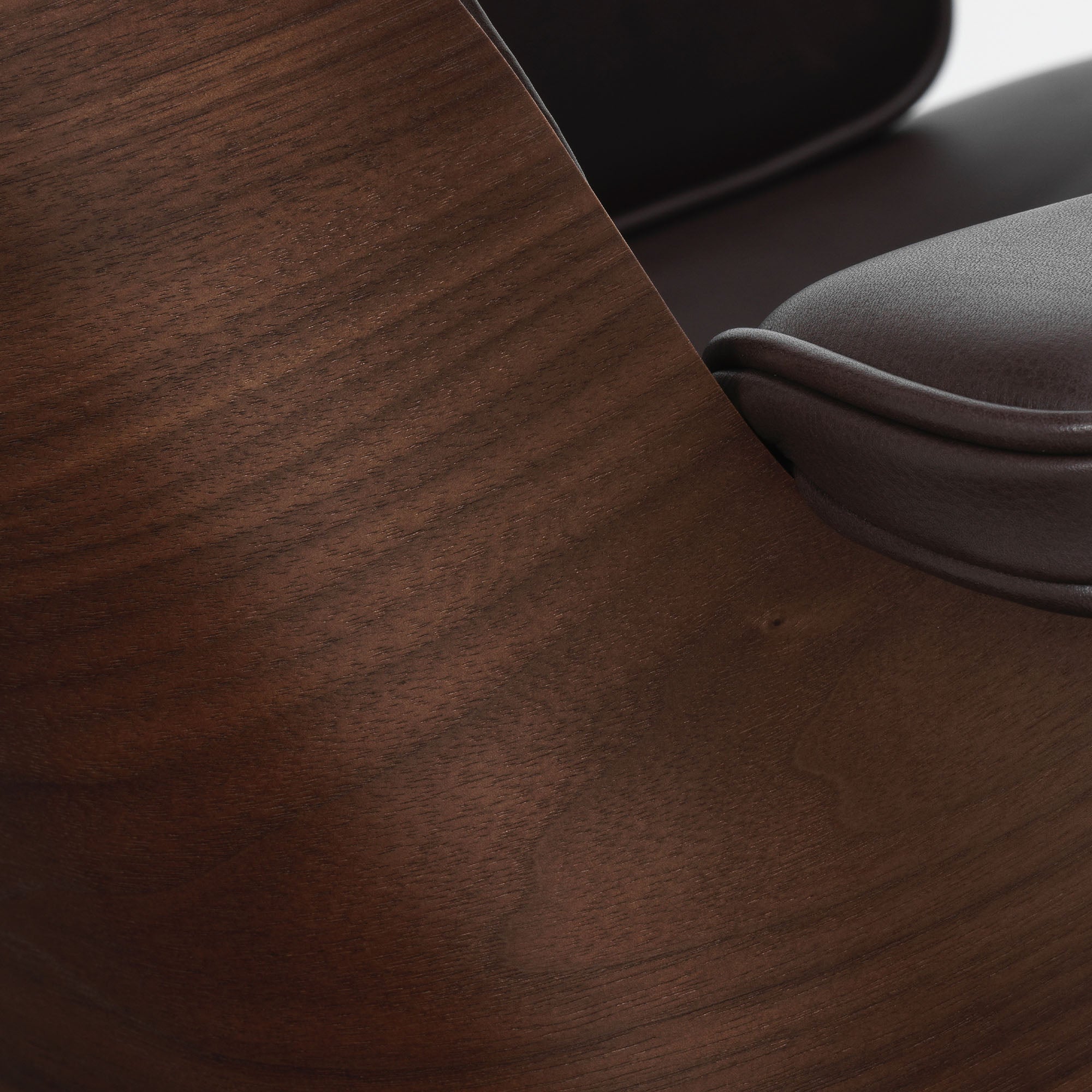 Eames Lounge Chair cu Otoman, lemn de nuc băițuit și bază satinată cu laterale negre