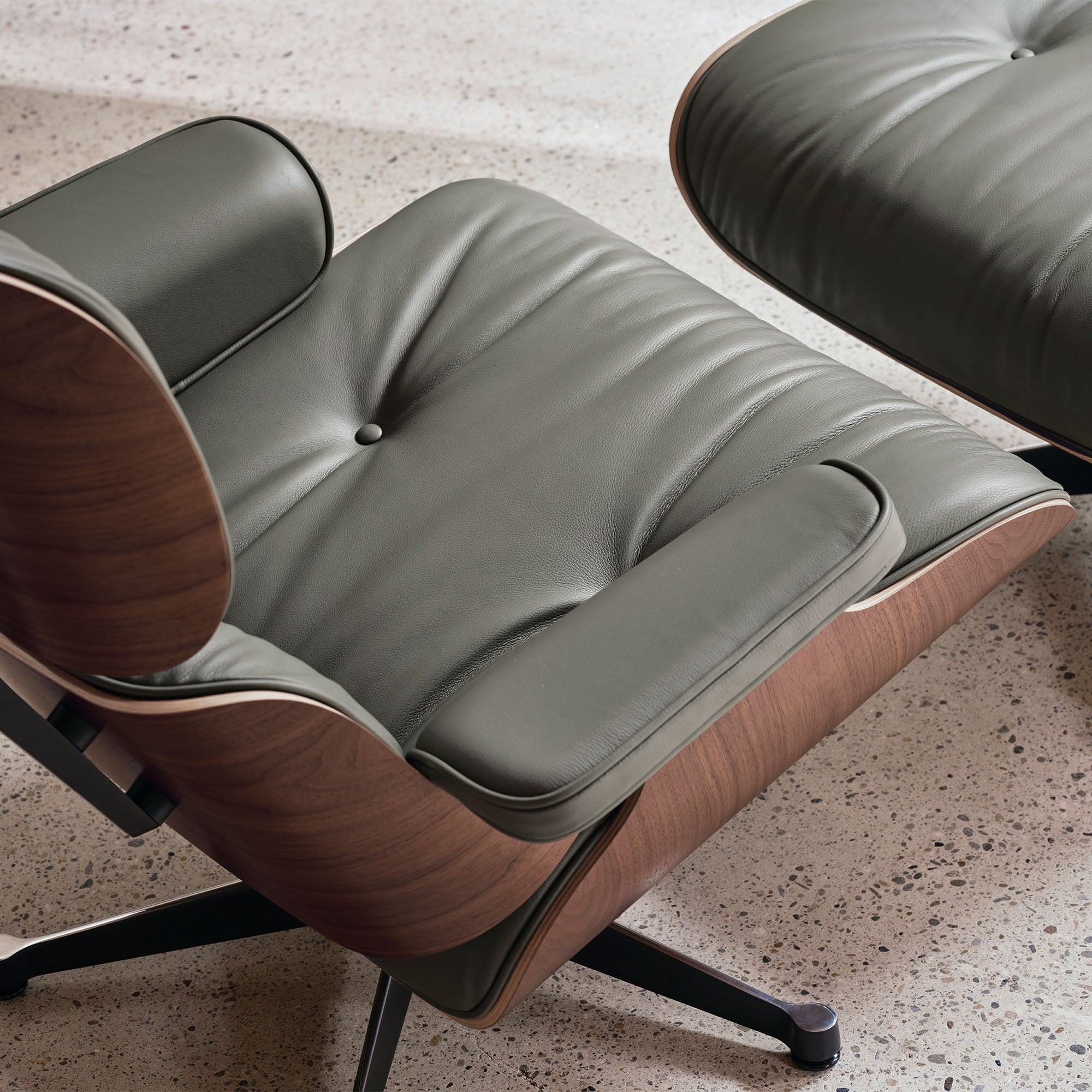 Eames Lounge Chair cu Otoman, lemn de nuc băițuit și bază satinată cu laterale negre