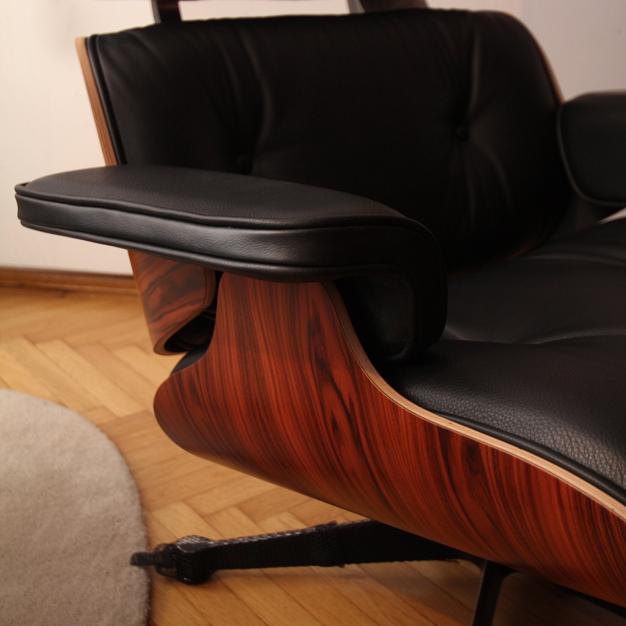 Eames Lounge Chair cu Otoman, lemn din palisandru și bază satinată cu laterale negre