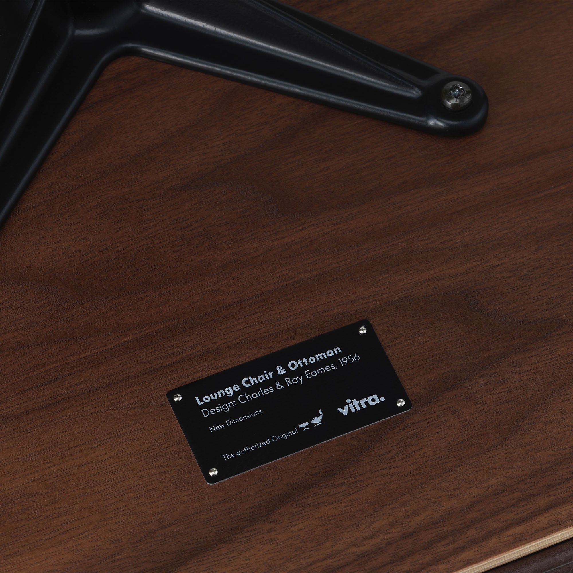 Eames Lounge Chair cu Otoman, lemn de nuc băițuit și bază satinată cu laterale negre